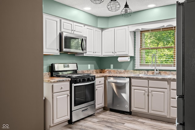 173 W Lakeview Dr, Nineveh, IN 46164 - kitchen featuring appliances with stainless steel finishes, white cabinets, light countertops, light wood finished floors, and a textured ceiling