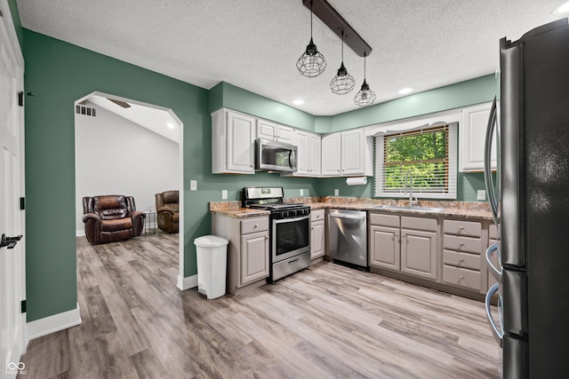 173 W Lakeview Dr, Nineveh, IN 46164 - kitchen featuring stainless steel appliances, a textured ceiling, light wood finished floors, pendant lighting, and light stone counters