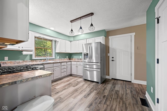 173 W Lakeview Dr, Nineveh, IN 46164 - kitchen with stainless steel refrigerator with ice dispenser, a textured ceiling, light wood-style flooring, white cabinets, and hanging light fixtures