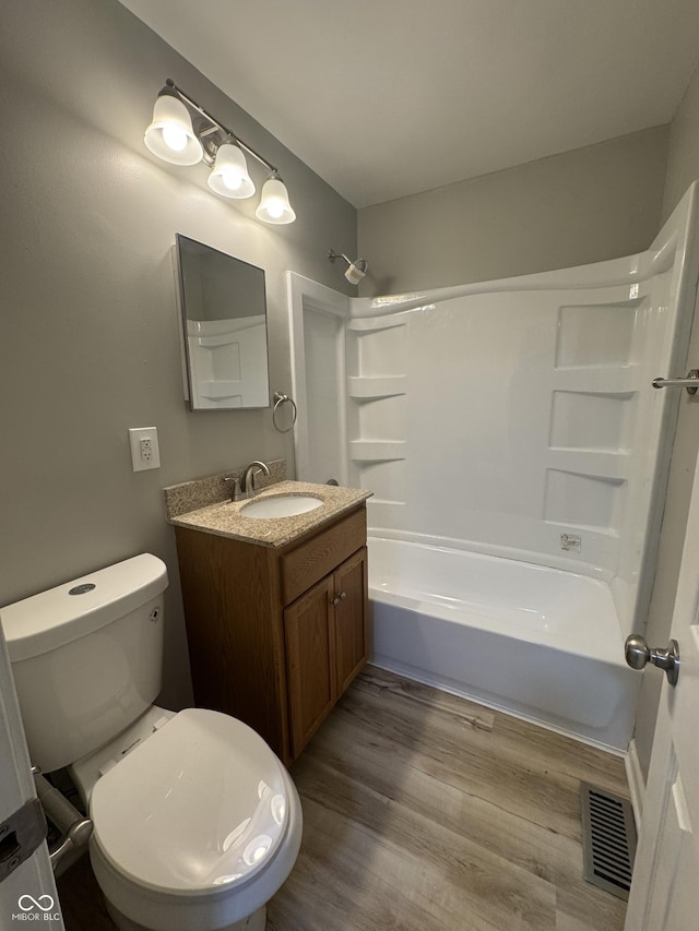 67 N Devon Ave, Indianapolis, IN 46219 - bathroom featuring vanity, washtub / shower combination, and wood finished floors