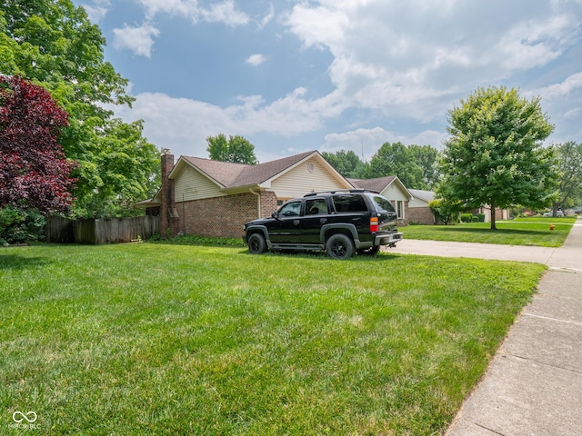 479 Raintree Dr, Danville, IN 46122 - view of home's exterior with brick siding, driveway, and a chimney