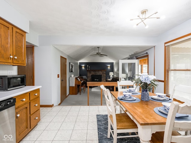 479 Raintree Dr, Danville, IN 46122 - dining space featuring ceiling fan, a brick fireplace, light tile patterned floors, and light carpet