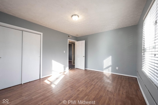 5737 E 22nd St, Indianapolis, IN 46218 - unfurnished bedroom featuring wood finished floors, a textured ceiling, and a closet