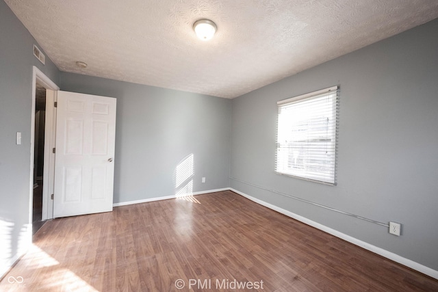 5737 E 22nd St, Indianapolis, IN 46218 - empty room featuring wood finished floors and a textured ceiling