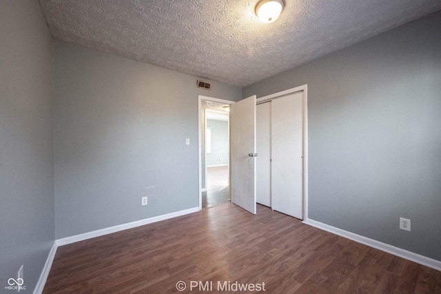5737 E 22nd St, Indianapolis, IN 46218 - unfurnished bedroom featuring wood finished floors, a closet, and a textured ceiling