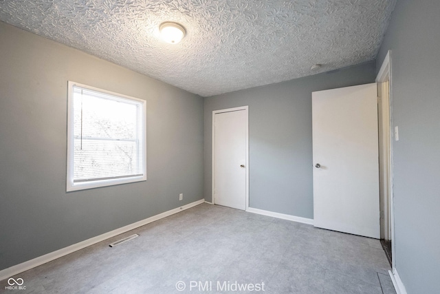 5737 E 22nd St, Indianapolis, IN 46218 - unfurnished bedroom featuring a closet and a textured ceiling