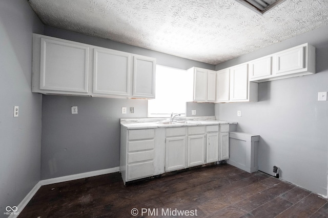 5737 E 22nd St, Indianapolis, IN 46218 - kitchen featuring dark wood-style flooring, white cabinets, light countertops, and a textured ceiling