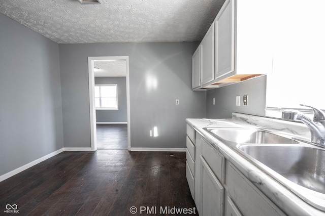 5737 E 22nd St, Indianapolis, IN 46218 - kitchen featuring dark wood finished floors, a textured ceiling, and white cabinets