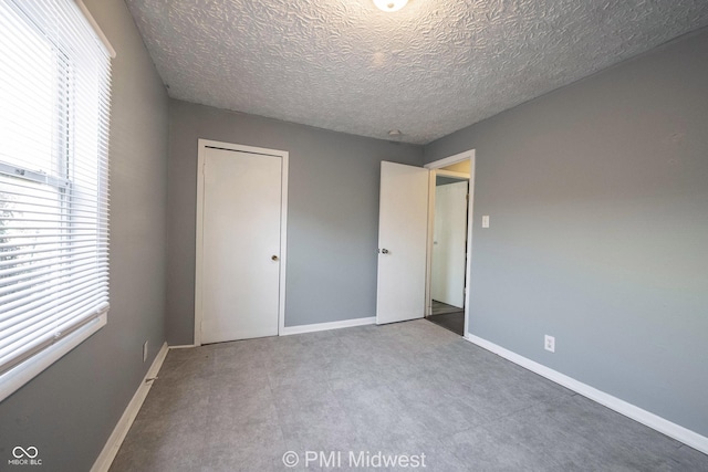 5737 E 22nd St, Indianapolis, IN 46218 - unfurnished bedroom featuring a textured ceiling, carpet, and a closet