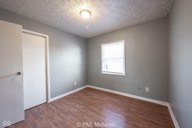 5737 E 22nd St, Indianapolis, IN 46218 - unfurnished bedroom with wood finished floors, a textured ceiling, and a closet
