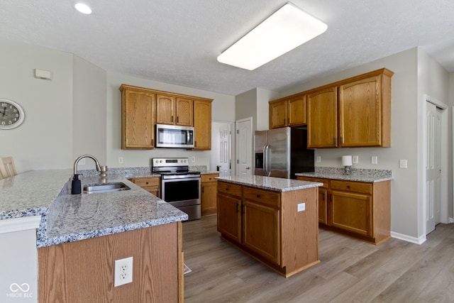 441 Viburnum Run, Westfield, IN 46074 - kitchen with a peninsula, stainless steel appliances, light wood finished floors, light stone countertops, and brown cabinetry