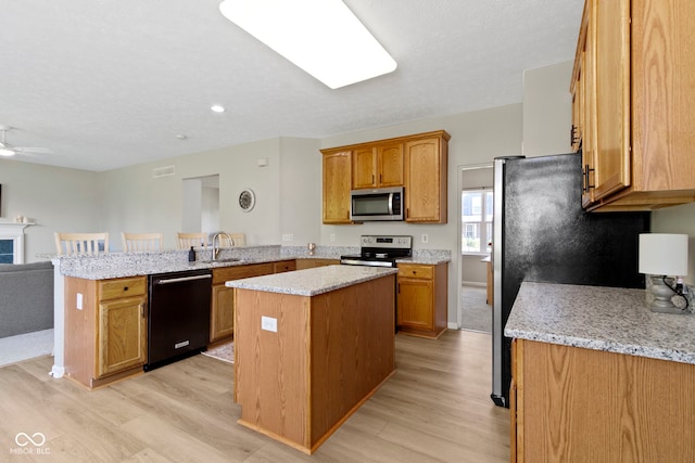 441 Viburnum Run, Westfield, IN 46074 - kitchen with a peninsula, light wood finished floors, a kitchen island, and appliances with stainless steel finishes