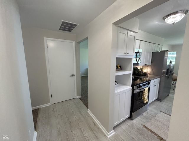 2692 Meadowlark Ln, Columbus, IN 47201 - kitchen featuring white cabinetry, light wood-style floors, and appliances with stainless steel finishes