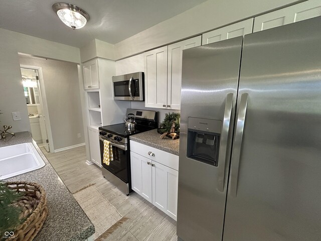 2692 Meadowlark Ln, Columbus, IN 47201 - kitchen featuring stainless steel appliances, white cabinetry, and light wood finished floors