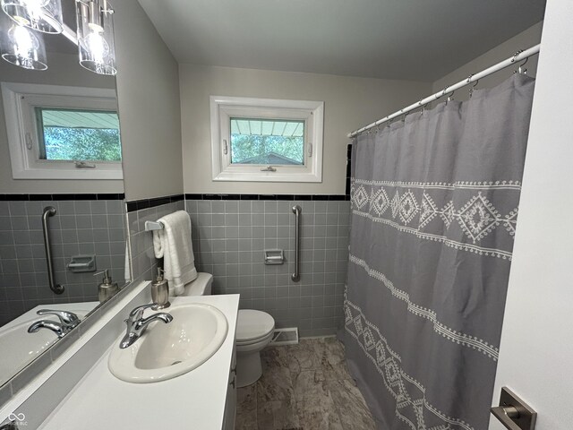 2692 Meadowlark Ln, Columbus, IN 47201 - bathroom with healthy amount of natural light, vanity, tile walls, wainscoting, and a shower with shower curtain
