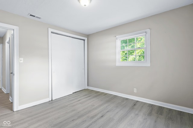 3945 N Ridgeview Dr, Indianapolis, IN 46226 - unfurnished bedroom with light wood-style flooring and a closet