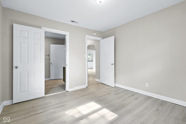 3945 N Ridgeview Dr, Indianapolis, IN 46226 - unfurnished bedroom featuring arched walkways and wood finished floors
