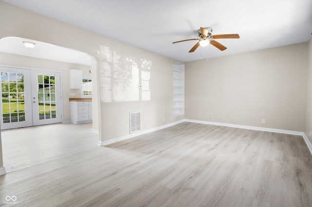 3945 N Ridgeview Dr, Indianapolis, IN 46226 - unfurnished living room featuring a ceiling fan, light wood-style floors, french doors, and arched walkways