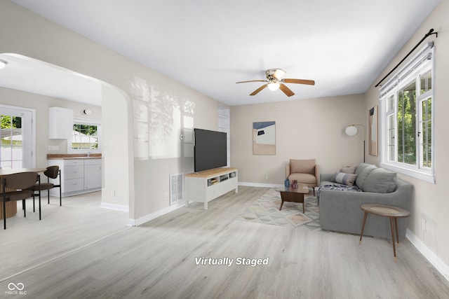 3945 N Ridgeview Dr, Indianapolis, IN 46226 - living room with light wood-style flooring, a ceiling fan, and arched walkways