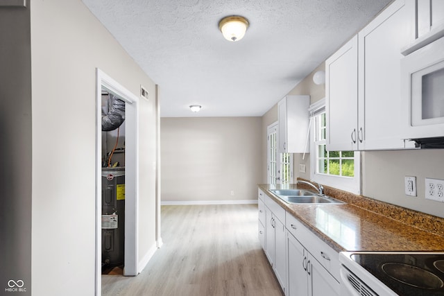 3945 N Ridgeview Dr, Indianapolis, IN 46226 - kitchen featuring light wood-style flooring, white cabinetry, white appliances, a textured ceiling, and electric water heater