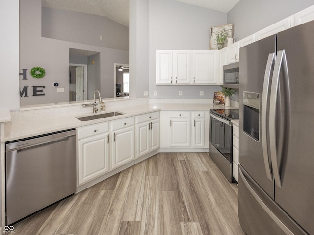 17019 Flinchum Way E, Noblesville, IN 46062 - kitchen with appliances with stainless steel finishes, vaulted ceiling, light wood-type flooring, light countertops, and white cabinets