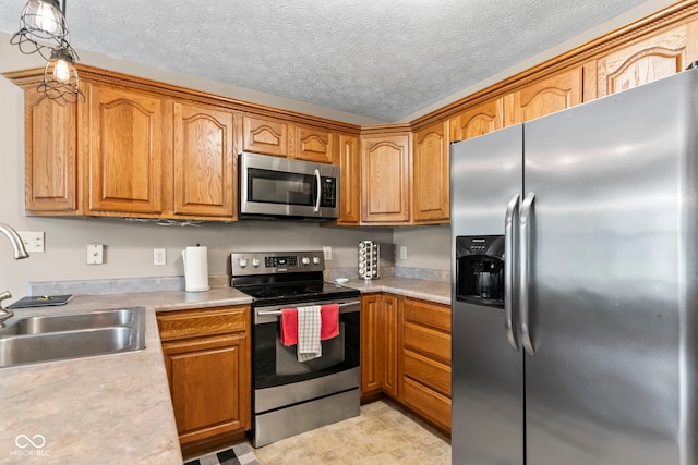 606 S Grange Hall Rd, Hanover, IN 47243 - kitchen featuring appliances with stainless steel finishes, light countertops, brown cabinetry, a textured ceiling, and hanging light fixtures