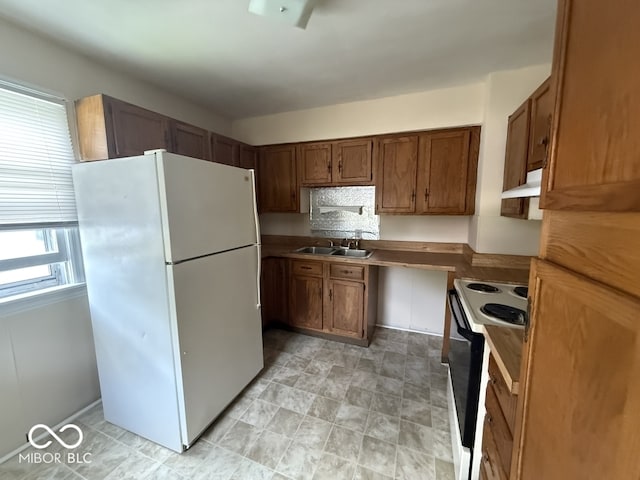 1048 S Burlington Dr, Muncie, IN 47302 - kitchen featuring freestanding refrigerator, black electric range oven, under cabinet range hood, and brown cabinetry
