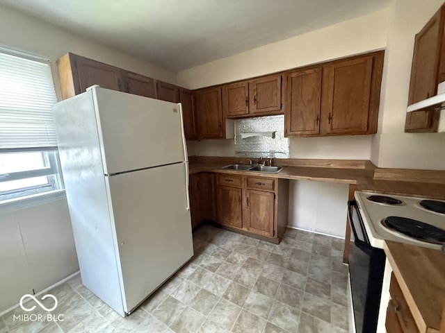 1048 S Burlington Dr, Muncie, IN 47302 - kitchen featuring freestanding refrigerator, black electric range oven, and brown cabinetry