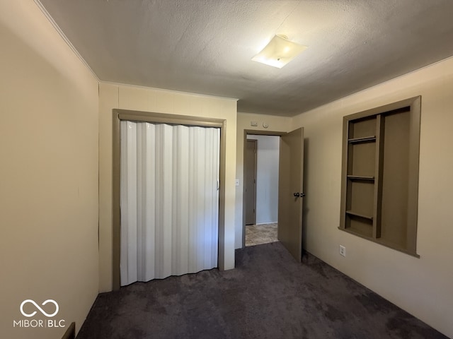 1048 S Burlington Dr, Muncie, IN 47302 - unfurnished bedroom featuring dark colored carpet and a textured ceiling