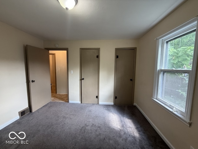 1048 S Burlington Dr, Muncie, IN 47302 - unfurnished bedroom featuring carpet and multiple closets