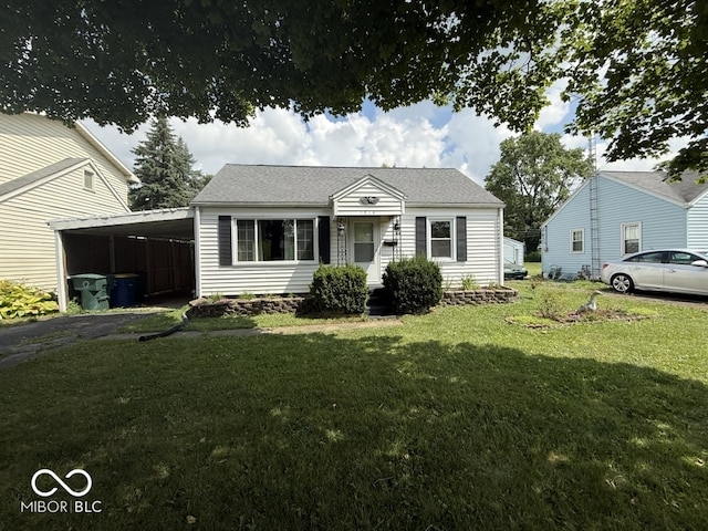 1914 E 23rd St, Muncie, IN 47302 - view of front of home with a carport, a front lawn, asphalt driveway, and roof with shingles