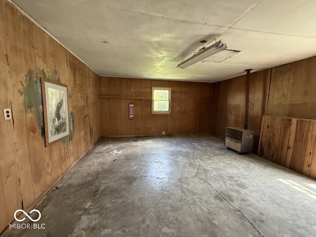 1914 E 23rd St, Muncie, IN 47302 - empty room featuring concrete flooring, heating unit, and wood walls