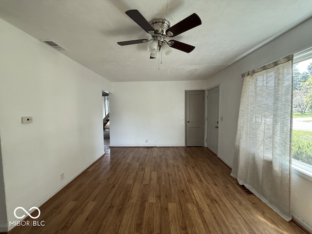 1914 E 23rd St, Muncie, IN 47302 - empty room with wood finished floors, a ceiling fan, and a textured ceiling