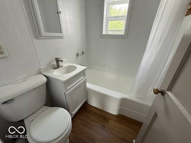 1914 E 23rd St, Muncie, IN 47302 - bathroom featuring tile walls, vanity, decorative backsplash, shower / bath combo, and wood finished floors