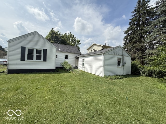 1914 E 23rd St, Muncie, IN 47302 - rear view of property featuring a yard, roof with shingles, and an outbuilding