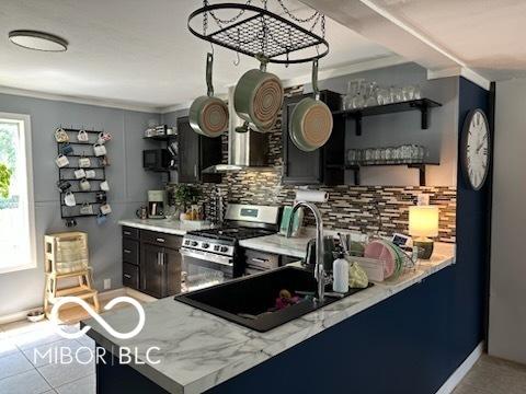 1129 Lafayette St, Elkhart, IN 46516 - kitchen with open shelves, stainless steel gas range, ornamental molding, tasteful backsplash, and light tile patterned floors