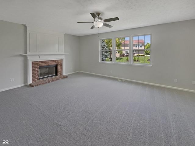 12089 Red Hawk Dr, Fishers, IN 46037 - unfurnished living room featuring a ceiling fan, a brick fireplace, carpet floors, and a textured ceiling