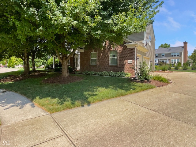 12089 Red Hawk Dr, Fishers, IN 46037 - view of front of property with driveway, brick siding, a front yard, and a garage