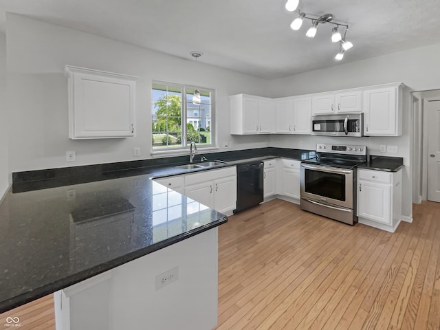 12089 Red Hawk Dr, Fishers, IN 46037 - kitchen featuring appliances with stainless steel finishes, white cabinets, light wood-style flooring, and a peninsula