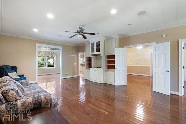 living room featuring ornamental molding, ceiling fan, and dark wood-type flooring