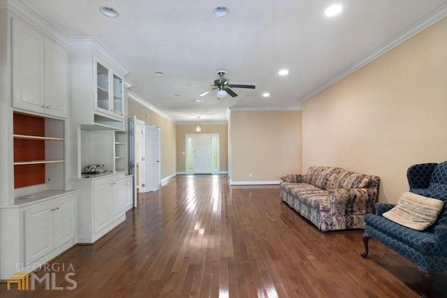 sitting room featuring ceiling fan, dark wood-type flooring, and ornamental molding