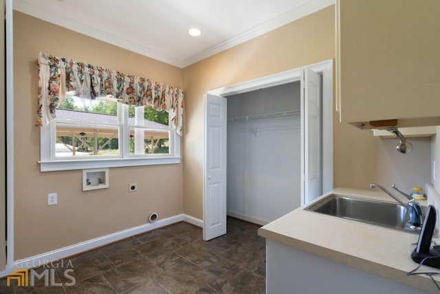 kitchen featuring ornamental molding, sink, and dark tile flooring