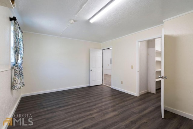 interior space with a textured ceiling, crown molding, and dark hardwood / wood-style flooring