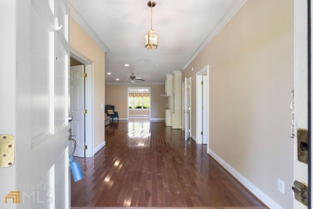 corridor featuring ornamental molding and dark wood-type flooring