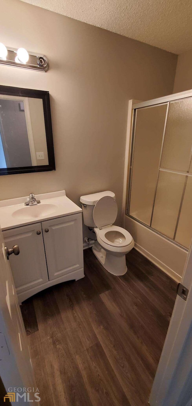 bathroom with vanity, hardwood / wood-style floors, a textured ceiling, and toilet