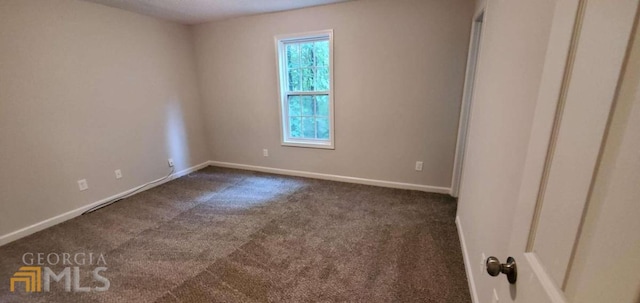 empty room with dark colored carpet