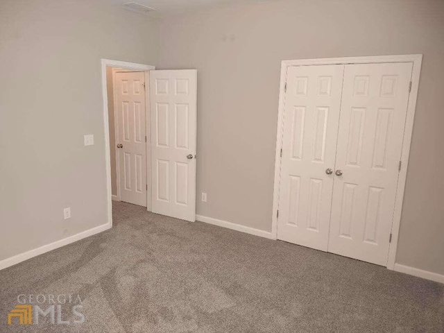 1208 Bordeau Way, Villa Rica, GA 30180 - unfurnished bedroom featuring a closet and dark carpet