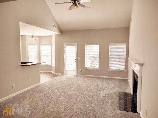 1208 Bordeau Way, Villa Rica, GA 30180 - unfurnished living room featuring lofted ceiling, light colored carpet, and ceiling fan with notable chandelier
