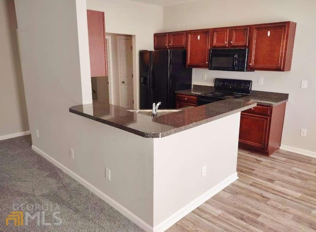 1208 Bordeau Way, Villa Rica, GA 30180 - kitchen with light hardwood / wood-style floors, black appliances, and sink