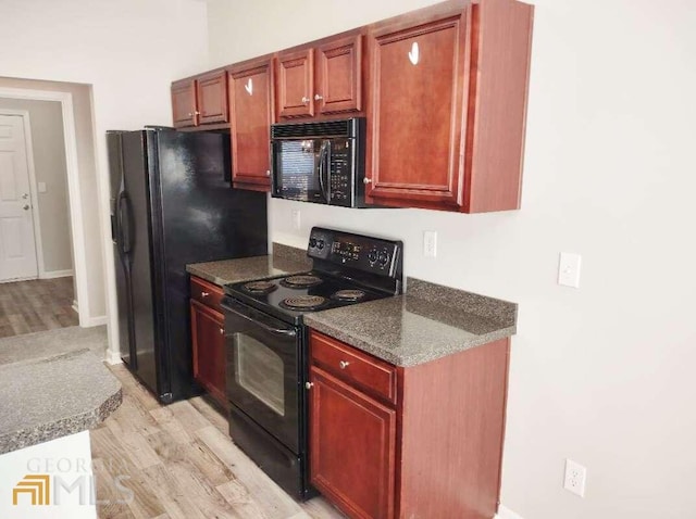 1208 Bordeau Way, Villa Rica, GA 30180 - kitchen featuring light wood-type flooring, dark stone countertops, and black appliances